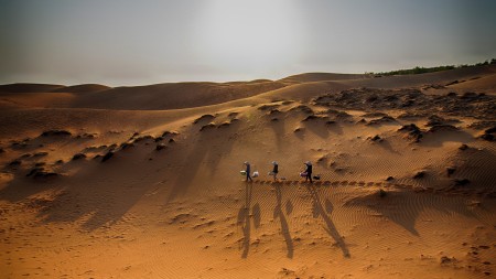 Walking to sell things in the sandhills at Phan Thiet