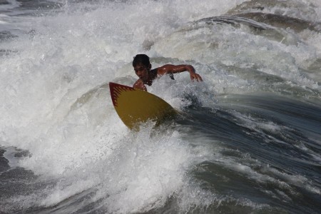 Memecah Ombak dengan Sebuah papan Surf