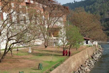 3 Monks strolling over the river bank of Punakha Dzong