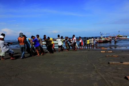 Bersama Menarik kapal ke pinggir pantai