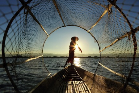 Fisherman Frames Through A Conical Fishing Net